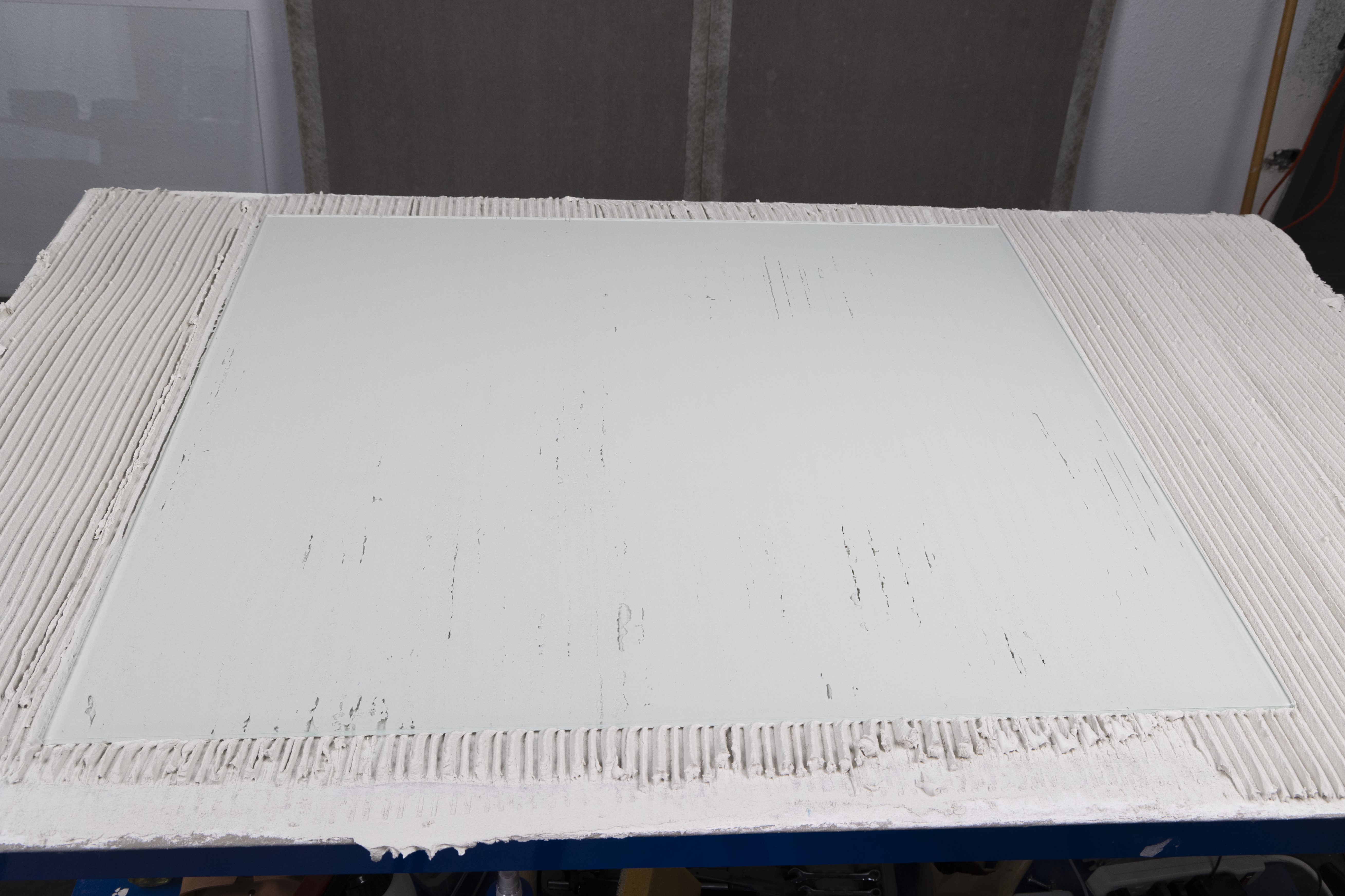 large glass tile shows the coverage rates of the Sawtooth notched trowel